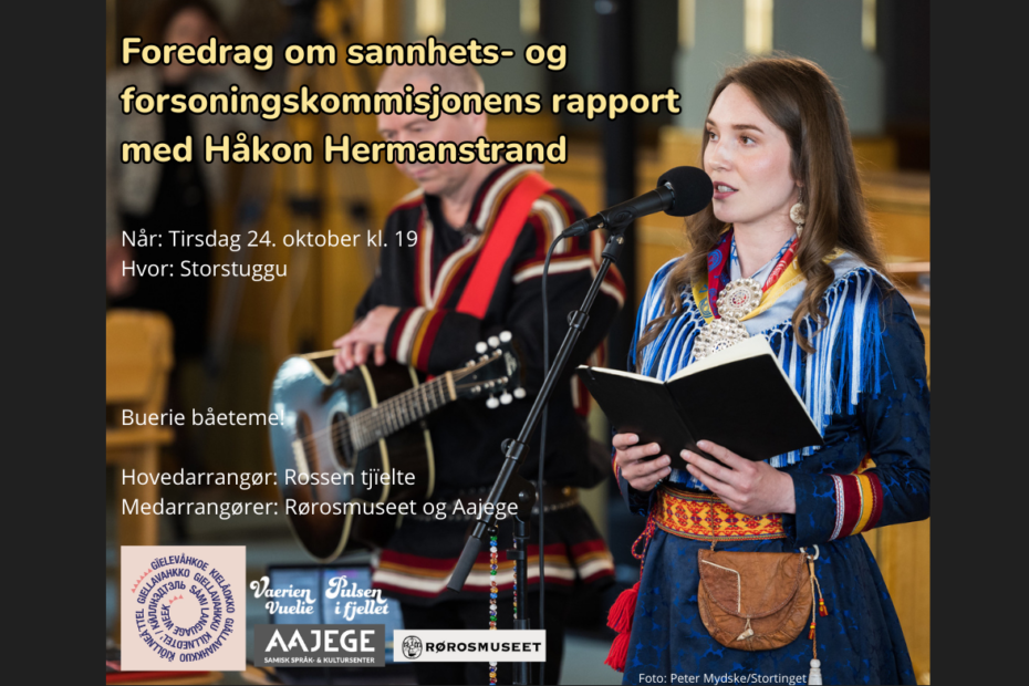 kvinne med samisk drakt som holder ei bok og snakker i en mikrofon